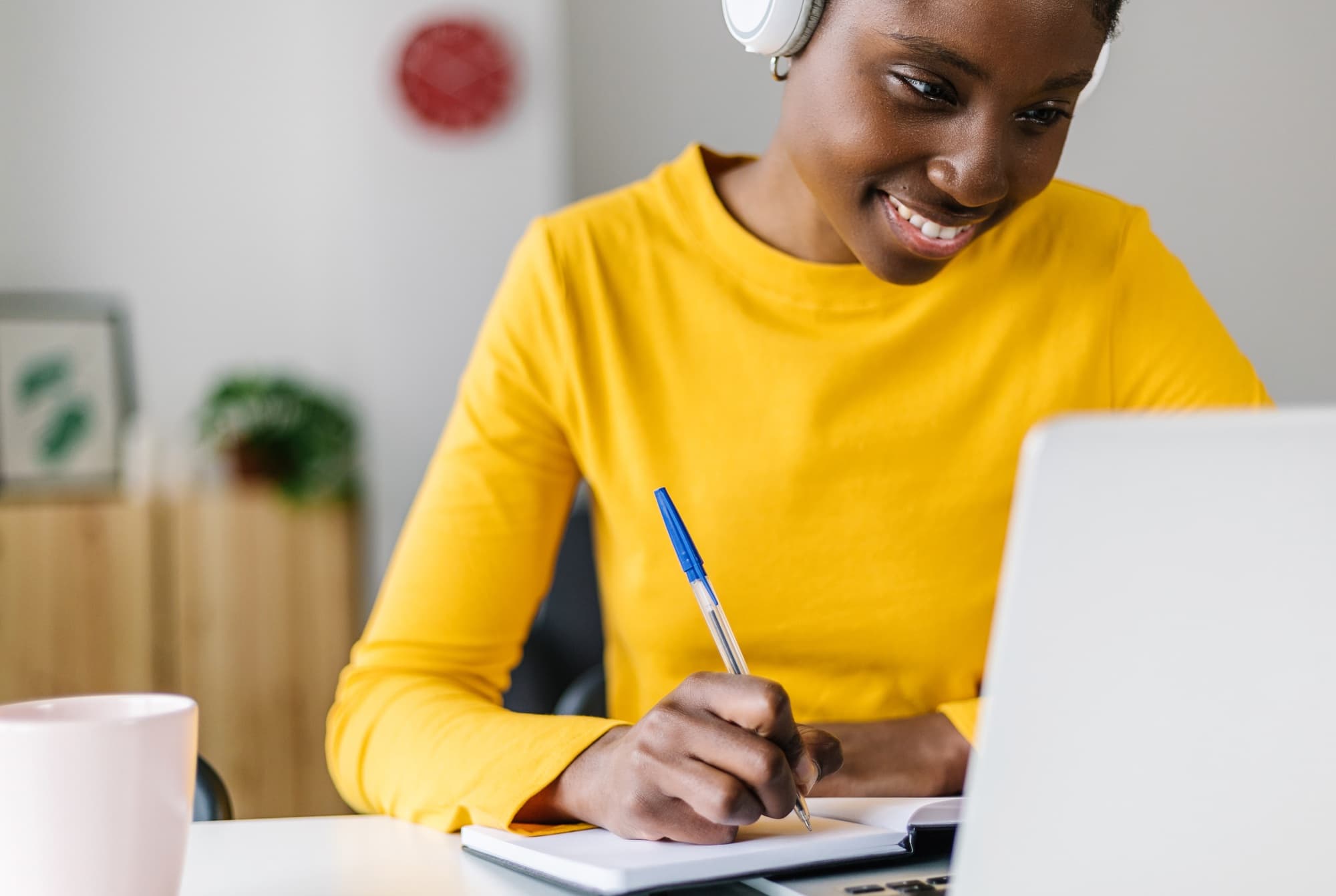 Smiling student using a laptop for online learning at home